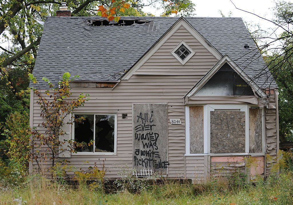 An abandoned home seen September 30, 2013 in Detroit, Michigan, is decorated with a piece of fencing and graffiti which declares 