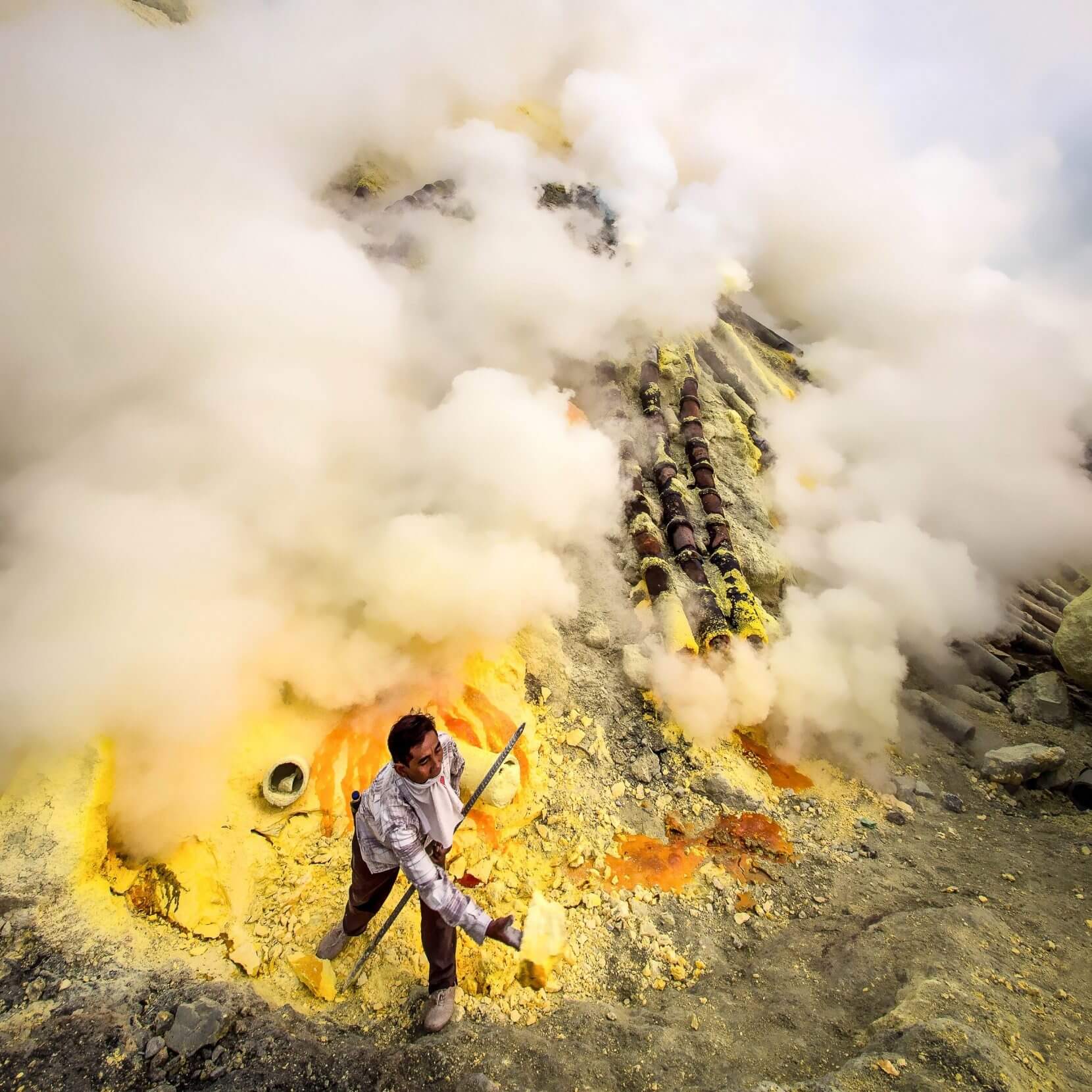 E9R636 Sulfur miner collecting sulfur at Kawah Ijen volcano in East Java, Indonesia.