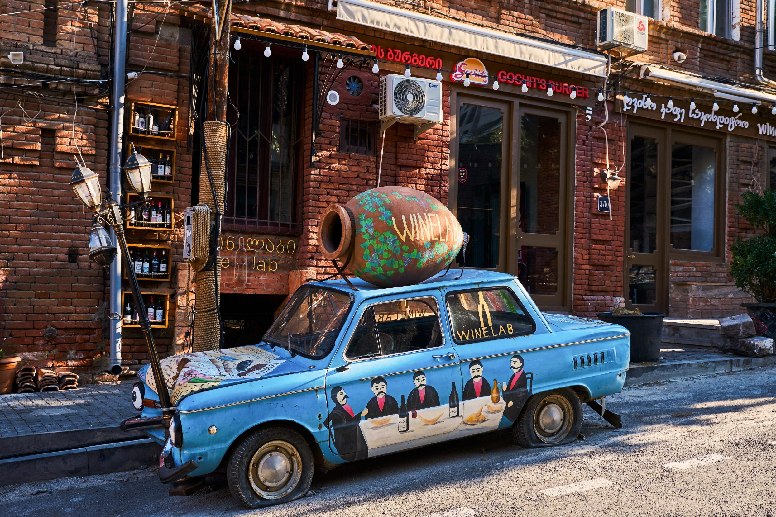 Traditional wine culture looms large in Georgian life, as encapsulated in this car decorated to promote a bar in Tbilisi. In addition to the qvevri pot on top, the billboard on wheels pays homage to native son and famed primitivist painter Niko Pirosmani, who frequently depicted scenes of rural life centered on wine traditions. Photo: Tuul and Bruno Morandi/Alamy.