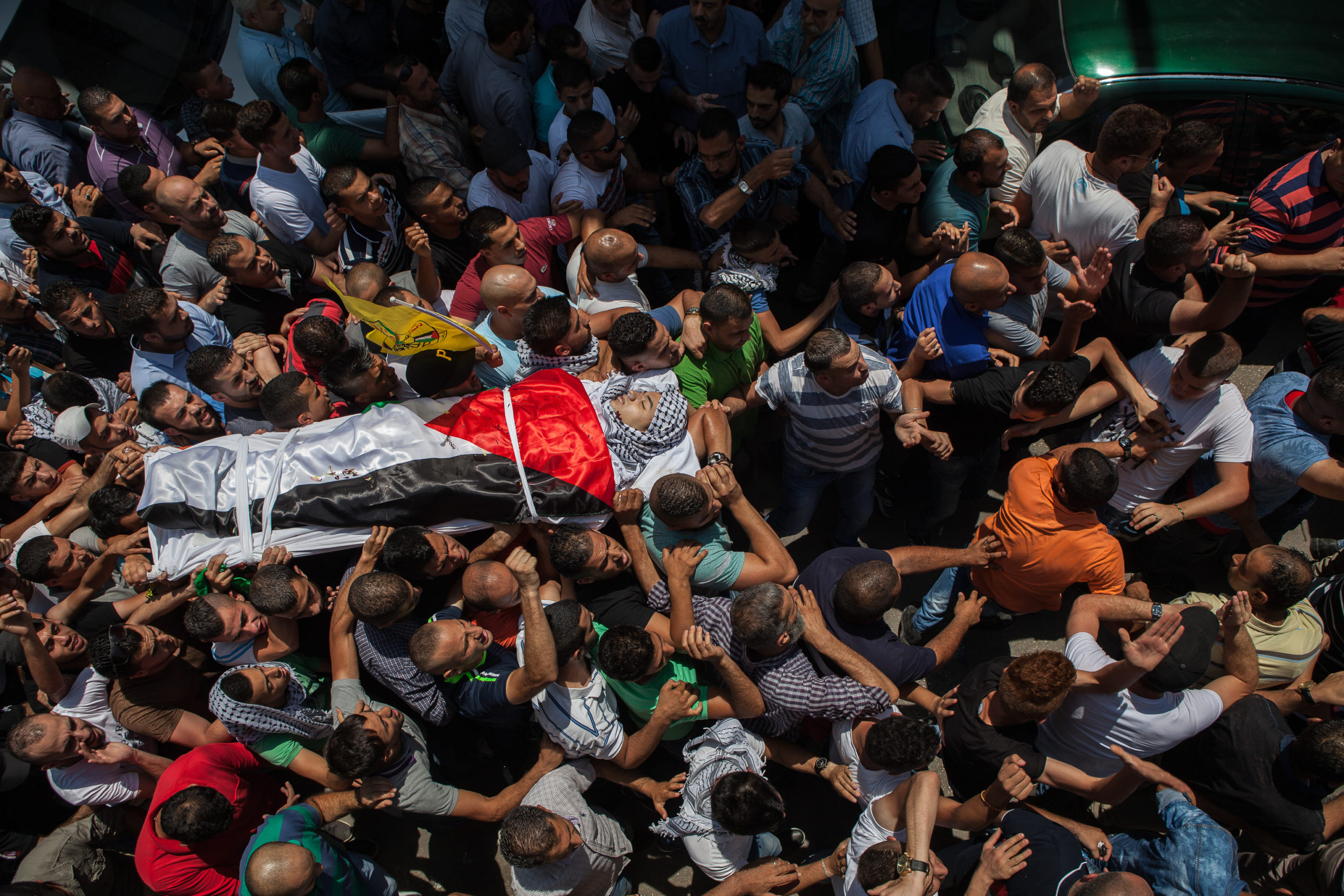 In August 2015, van Rijn found herself covering back-to-back tragedies: the death of an infant when Israeli settlers started a fire in his home and the subsequent death of a 17-year-old shot at a refugee camp while protesting the first child’s death. Here, the body of the latter is wrapped in a Palestinian flag as a funeral procession carries him. Photo: Edmée van Rijn.
