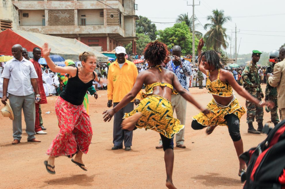Women dance together in the street during a festival celebrating music and dance in Faranah, Guinea. Photo: Lilli Rannikko.