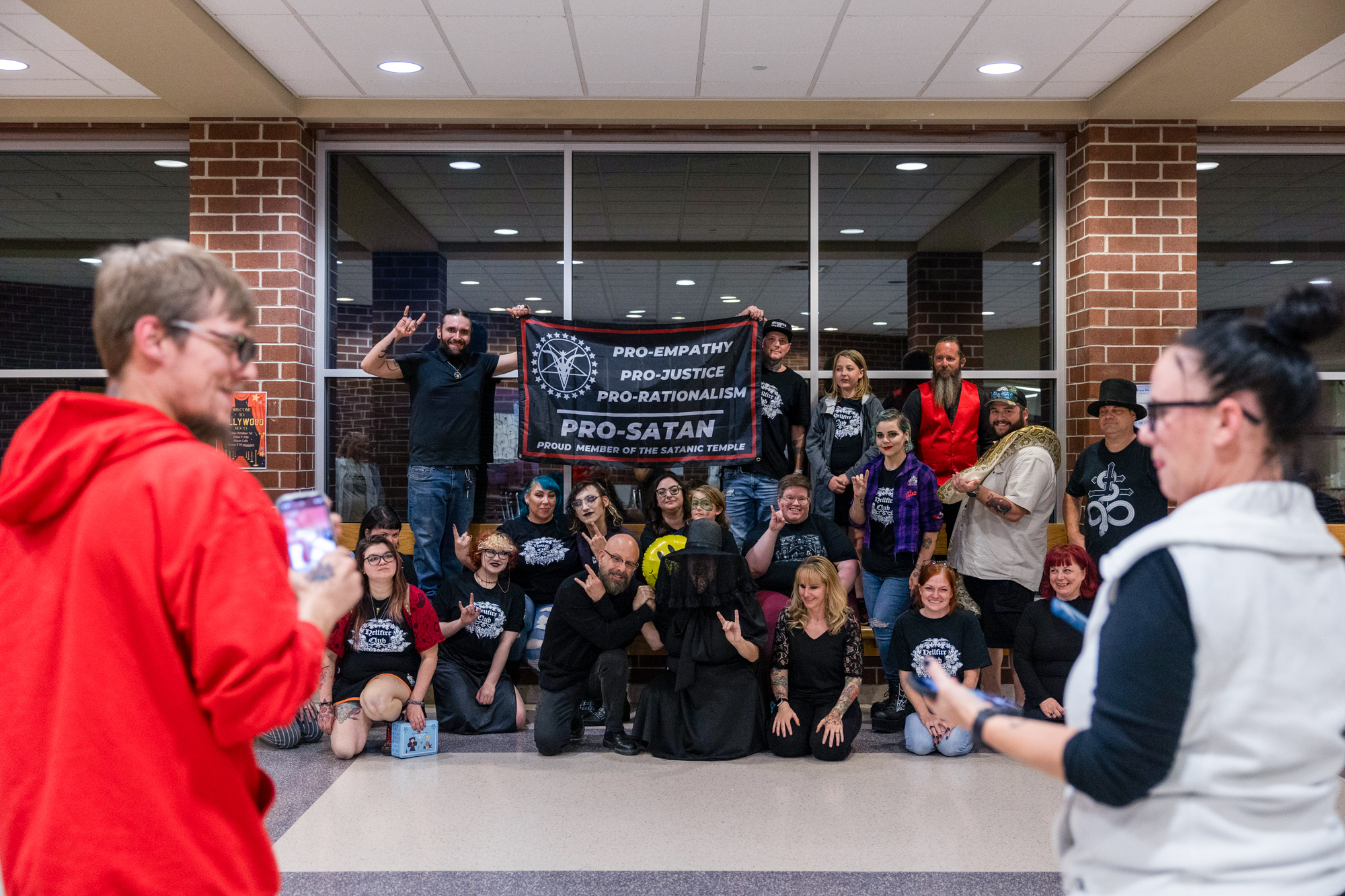 A group photo of kids, adults, and a snake with a banner reading 