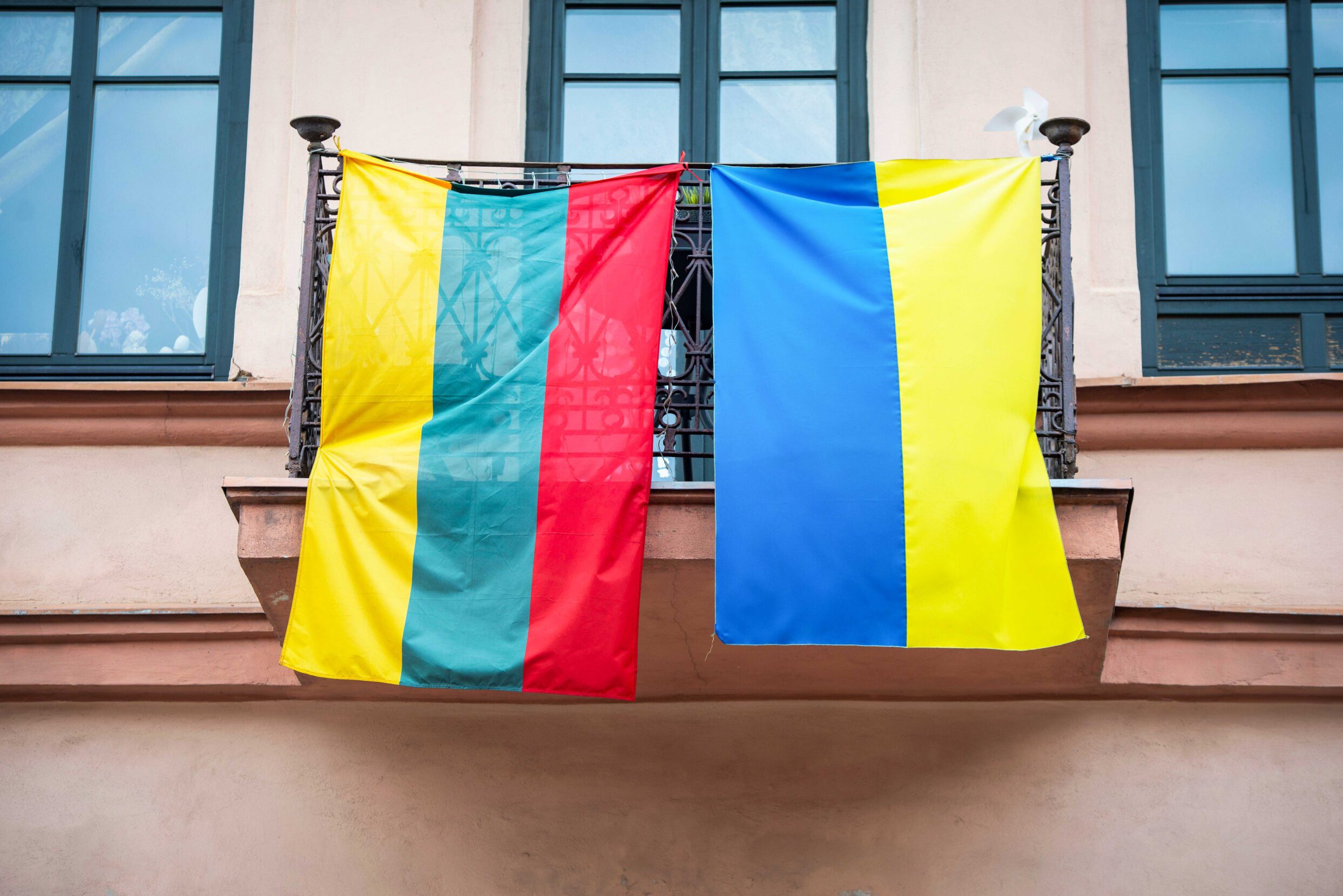 Flags of Ukraine (blue and yellow) and Lithuania (yellow, green, red) on a balcony in a street in Vilnius, Lithuania