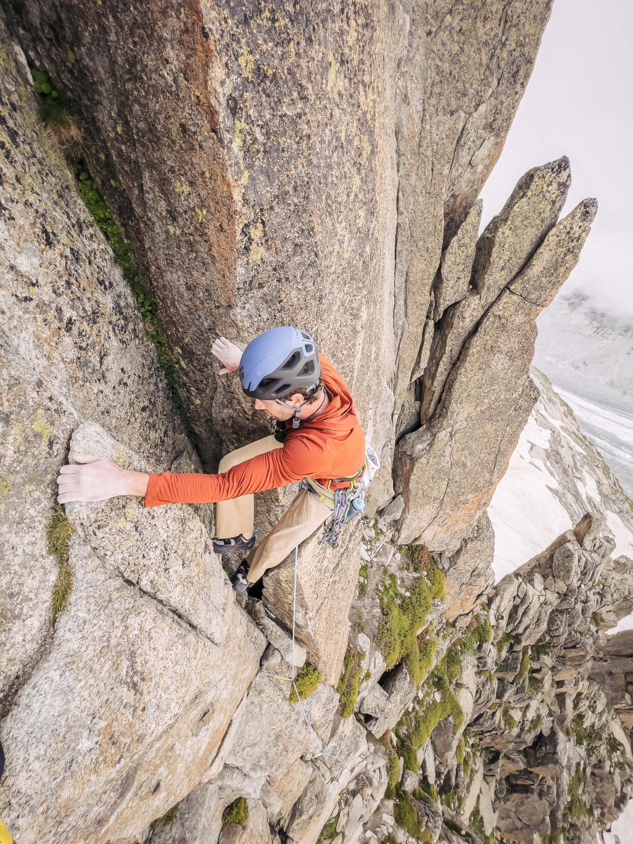 a man climbing a vertical rock face.