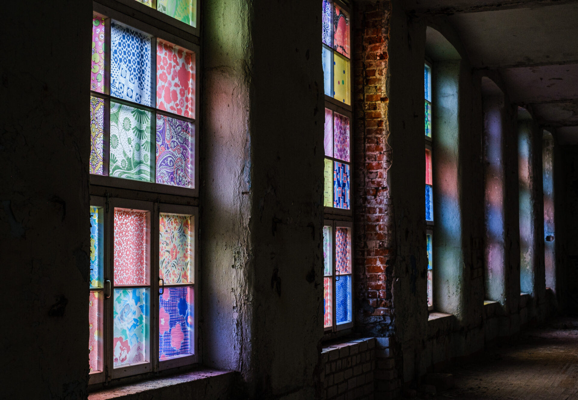Windows with colorful textiles glow like stained glass.