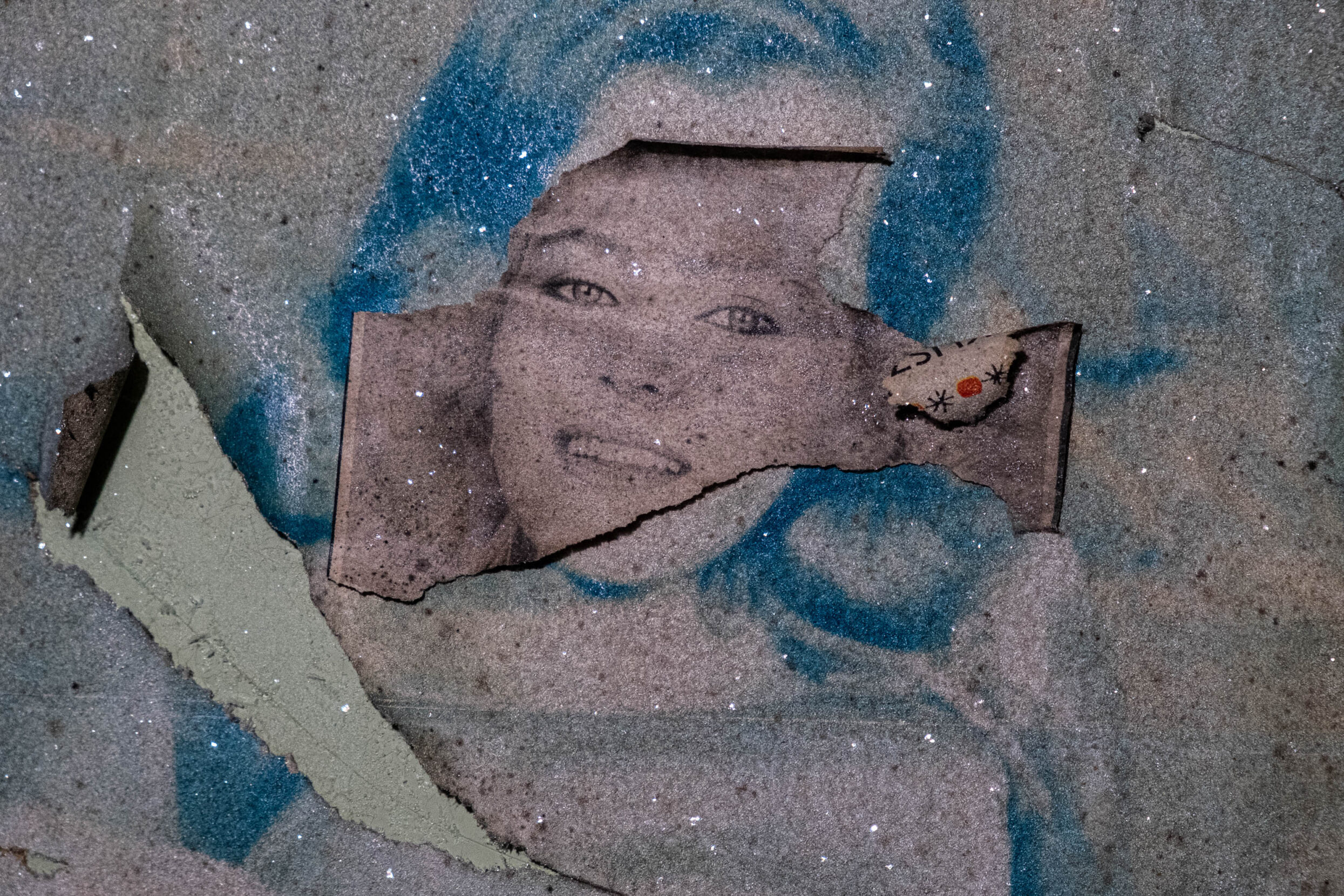 A peeling photo of a female movie star sparkles with frost.