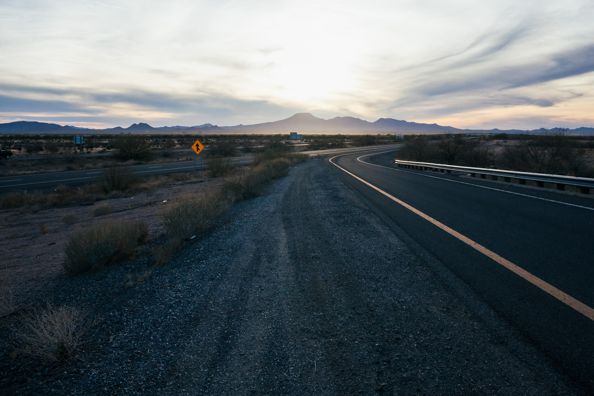 The smooth blacktop of a highway winds into the distance.