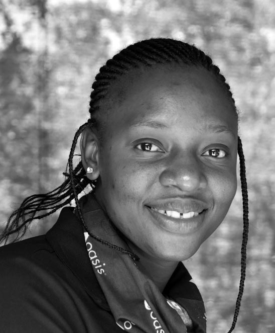 Black and white portrait of a smiling Black woman with braided hair.